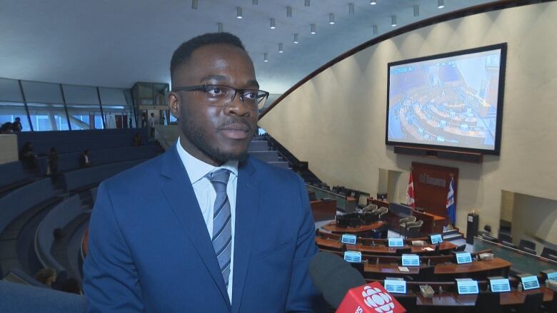 Stephen Mensah, executive director of the Toronto Youth Cabinet, stands inside city hall.