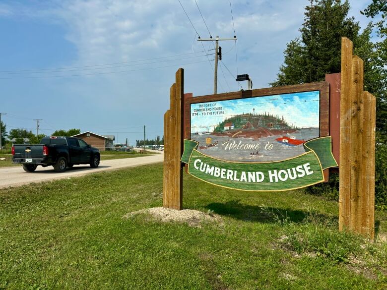 Cumberland House welcome sign as truck drives by