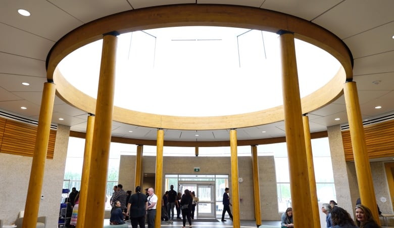 People disperse near pillars under a skylight. 