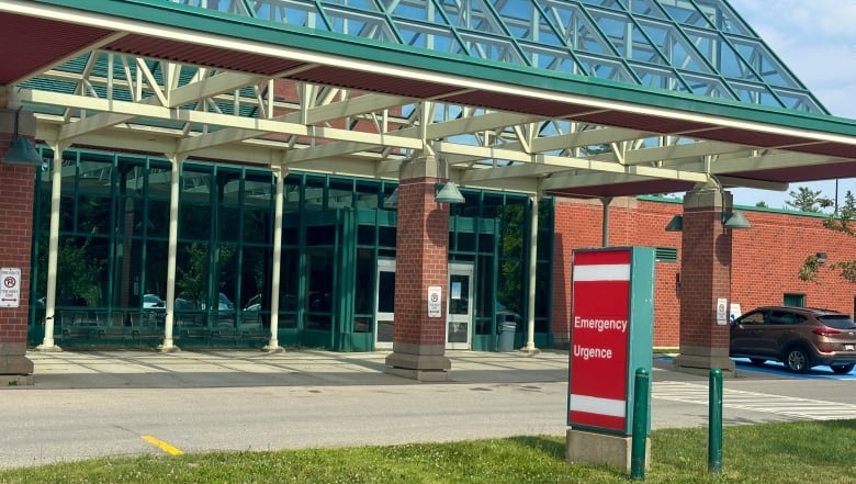 Hospital entrace with red sign in foreground. 