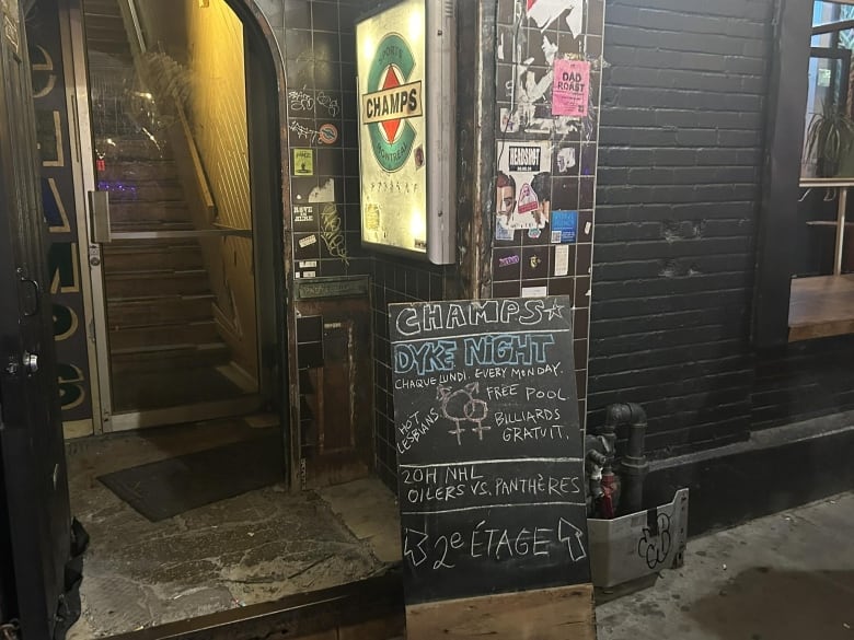 outside of Champs bar with a chalk board advertising Dyke Night events