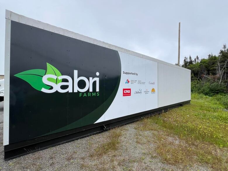 Shipping container shaped facility with Sabri logo sits in field