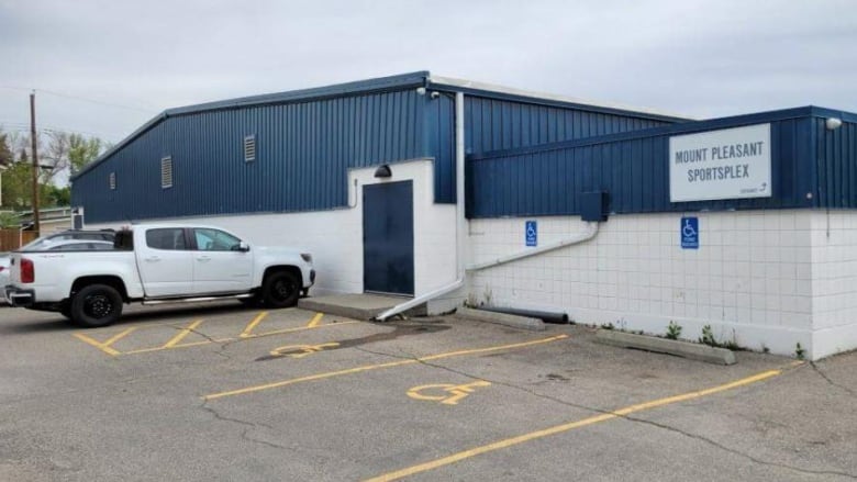 A blue building with a white truck parked outside.