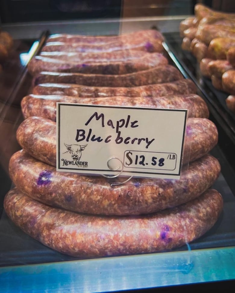 Sausages are stacked in a tray, labelled maple blueberry.