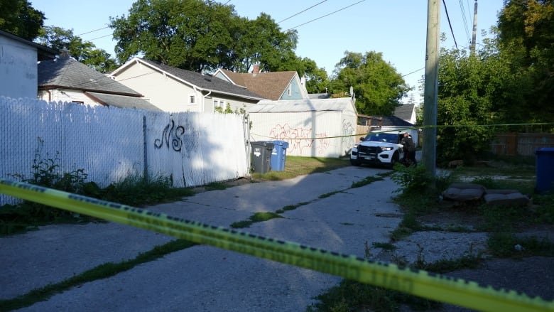 Police car and tape on the back of a house on redwood ave