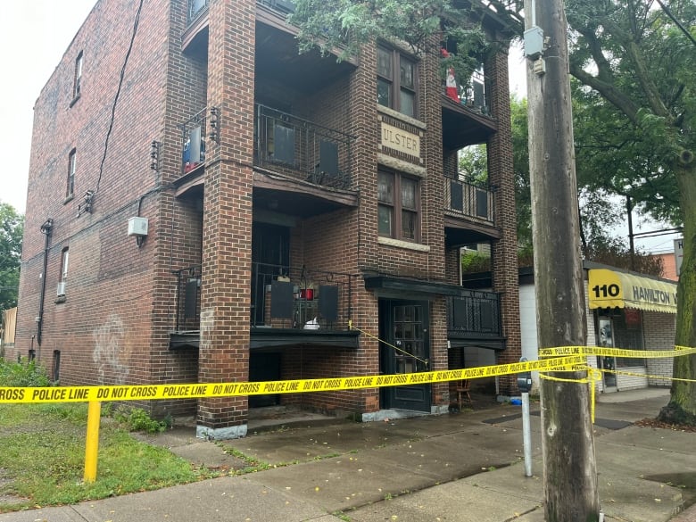 Police tape in front of an apartment building.