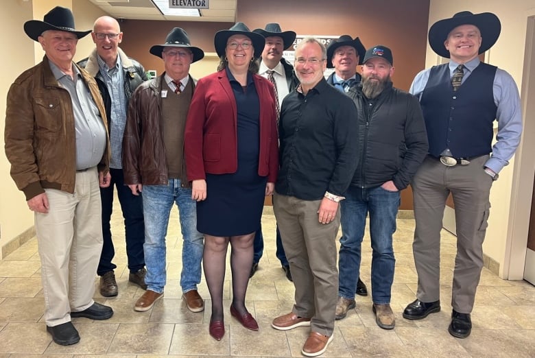 A group, mostly men, mostly in black hats.