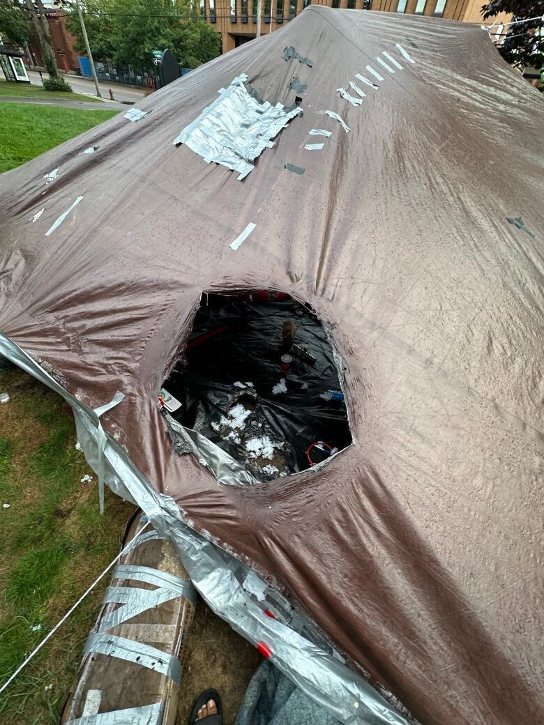 Tent with burned out hole in it.