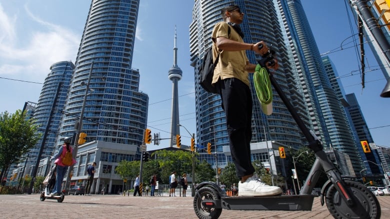 e-Scooter riders are photographed on Queen's Quay in Toronto, on Aug. 22, 2023.