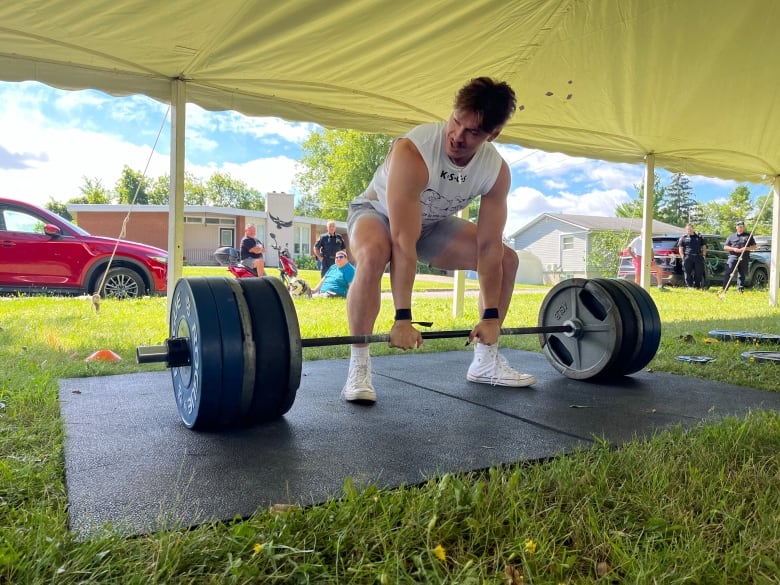 A man squatting to do a deadlift.