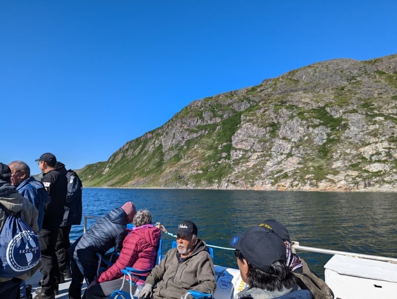 Elders sit outside on the ship setting sail towards Nutak