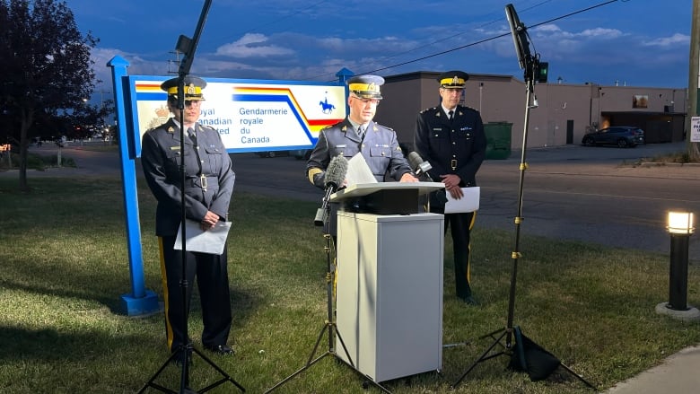 A man stands behind a podium in a police uniform. 