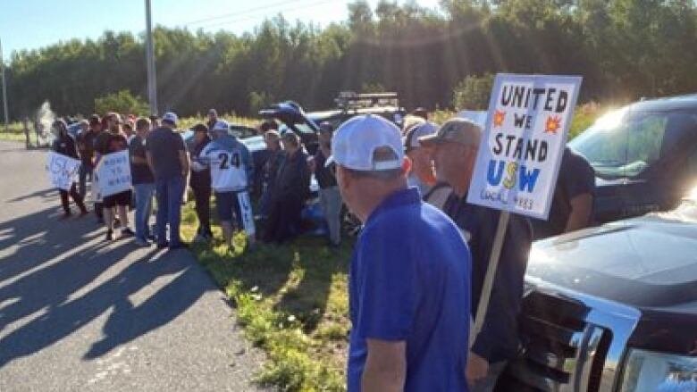 People with signs on a sunny day. 