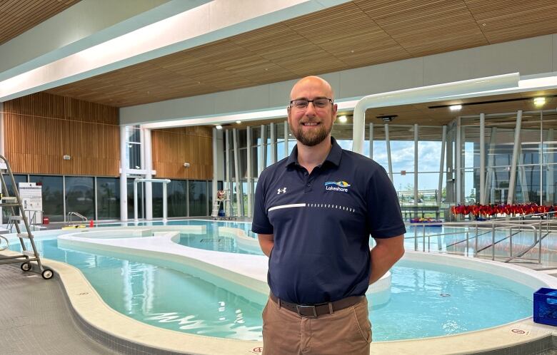 A man in a large indoor pool facility.