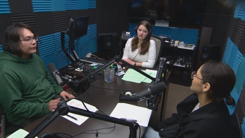 Three young adults sit in a radio studio.