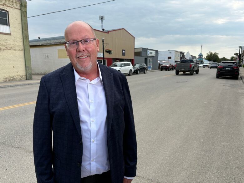 Kevin Weedmark pictured standing on Main Street with businesses and traffic behind him