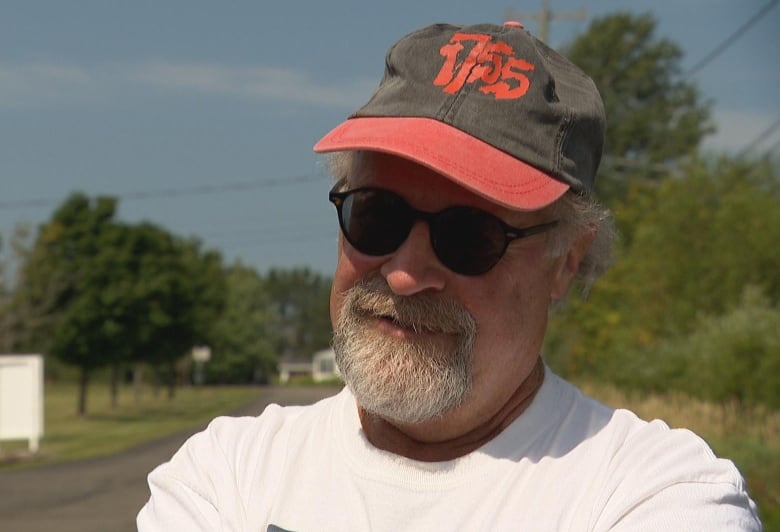 a man in a black and red hat stands outside