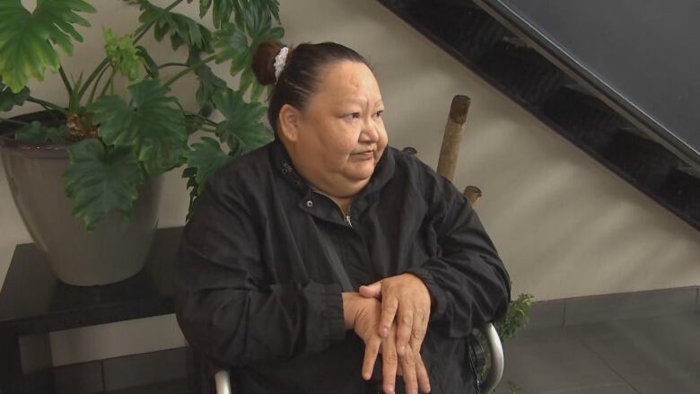 A woman on black sweater sits on a wheelchair 