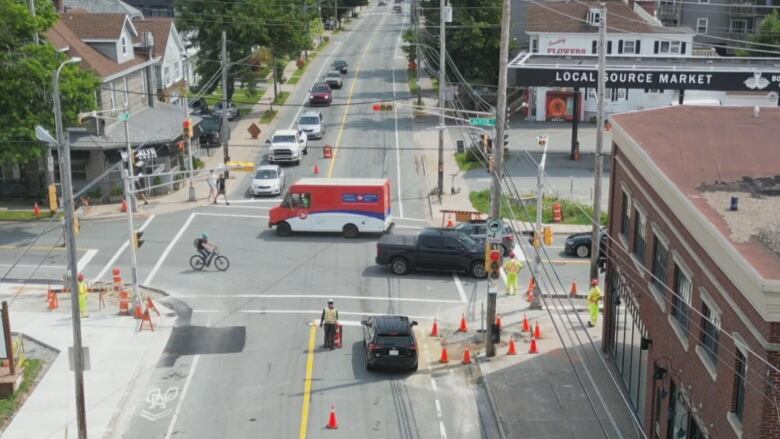 Busy intersection photo taken from drone showing construction, a truck, multiple cars and a bike. 