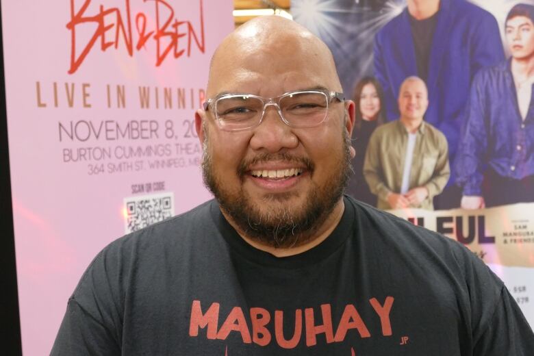 A Filipino man with glasses smiles for the camera.