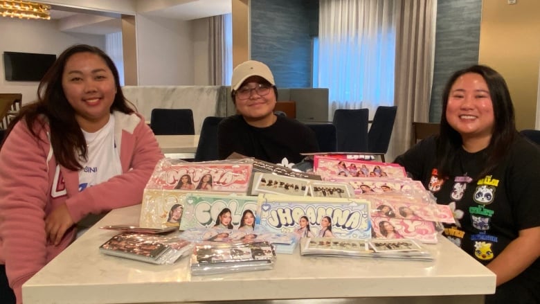 A group of girls sit around a table filled with hand posters