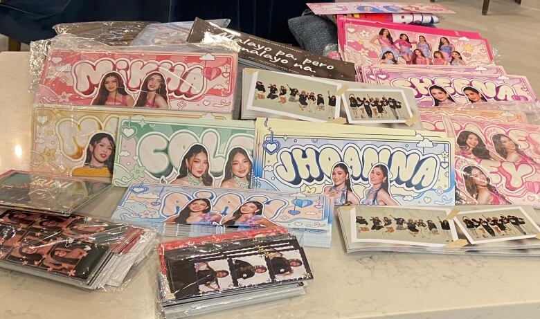 Fan-made merchandise of hand banners and bookmarks overflow the table.