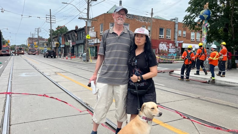 Photo of a man, woman and dog downtown 