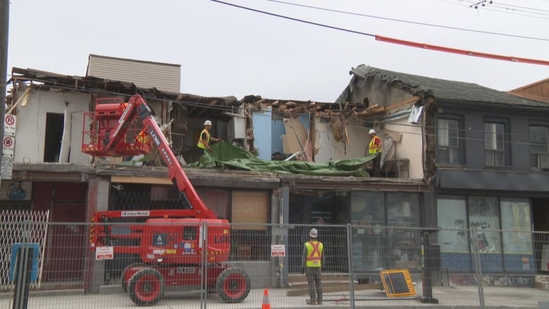 Photo of construction crews on a partially demolished building