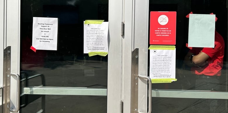 A door with some signs taped to it.