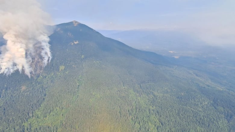 White smoke billows from a mountainside.