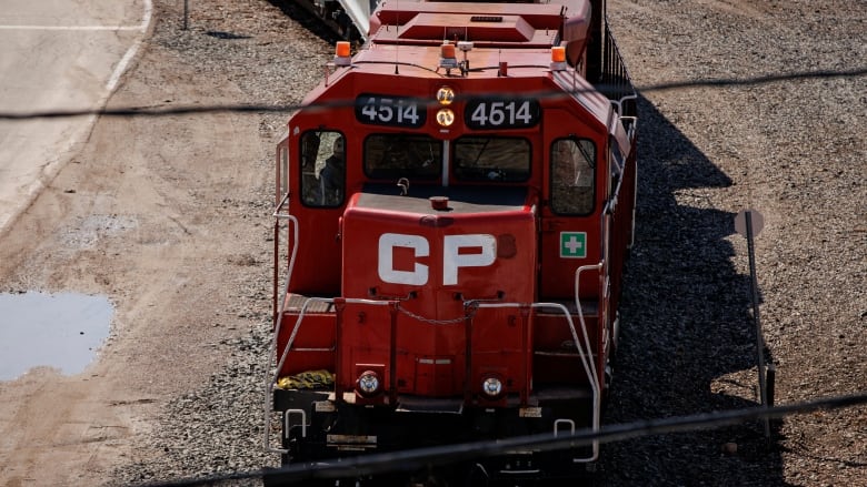 A bright red locomotive faces the camera in a rail yard. Big letters, CP, are painted on the front.