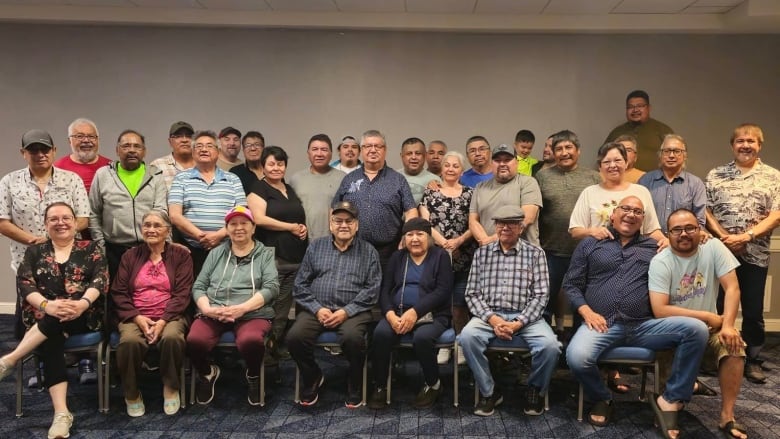 A group of Cree men and women smile at the camera.