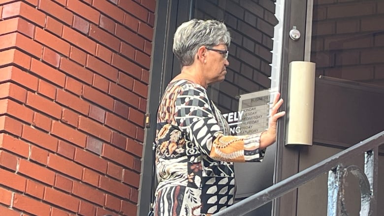 Woman opens door to enter court.