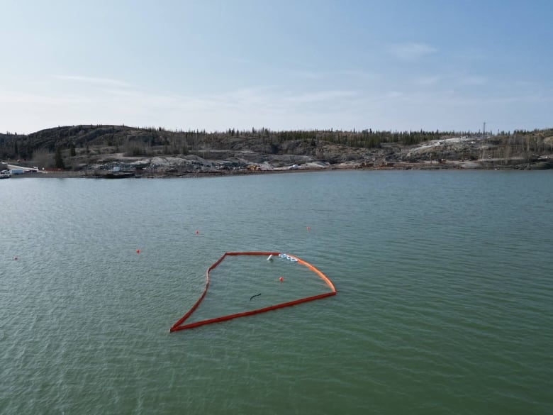 A drone shot above water with a red shape in the water. 