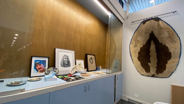 portraits and artifacts behind a glass display