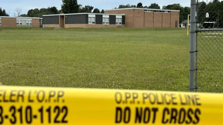 Police tape surrounding an abandoned school where police collected evidence following a 13 year old boy being charged in the death of a 12 year old girl in the area 