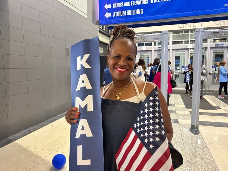 Woman holding a U.S. flag and a Kamala Harris sign