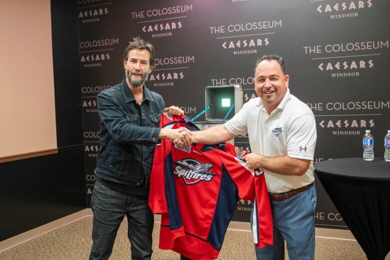 Reeves shakes hands with the general manager of the Windsor Spitfires Bill Bowler while at The Colosseum at Caesars Windsor on Aug. 22, 2024.