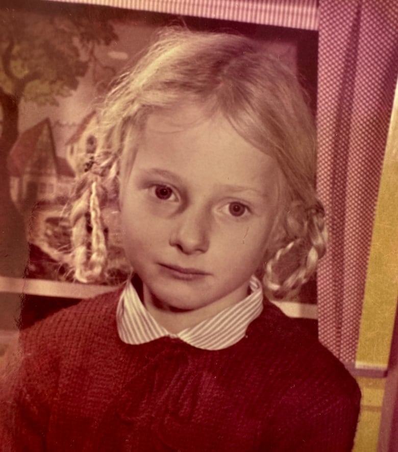 A young girl with her hair in two braids that are looped.