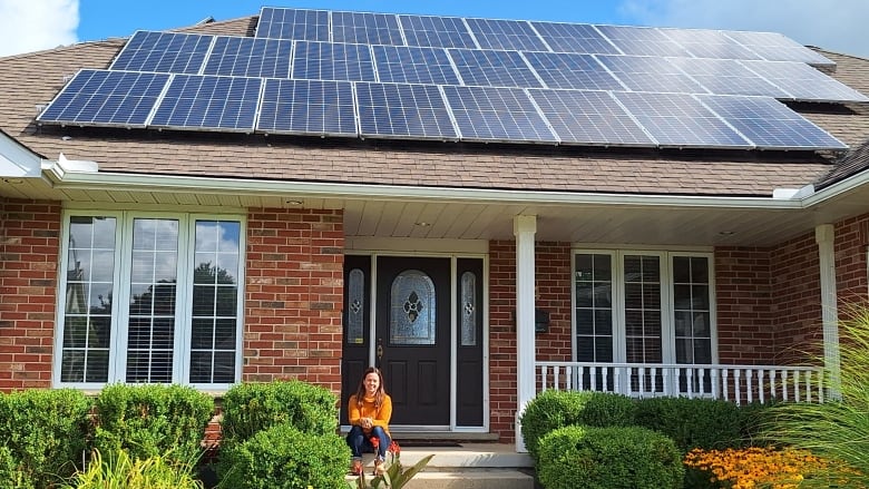 woman in front of house with solar panels