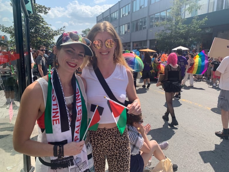 Two woman at the Capital Pride Parade holding Palestine flags. 