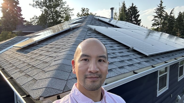 Man in front of a roof with solar panels