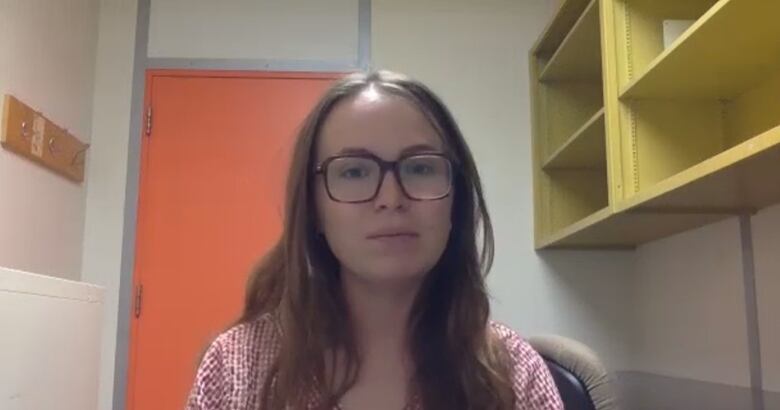 A Caucasian woman with glasses and long brown hair. 