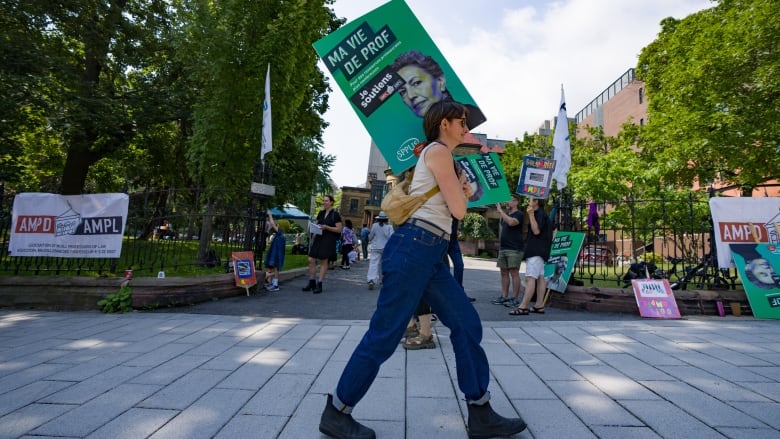 McGill University law professors strike outside the law faculty in Montreal carrying signs. 