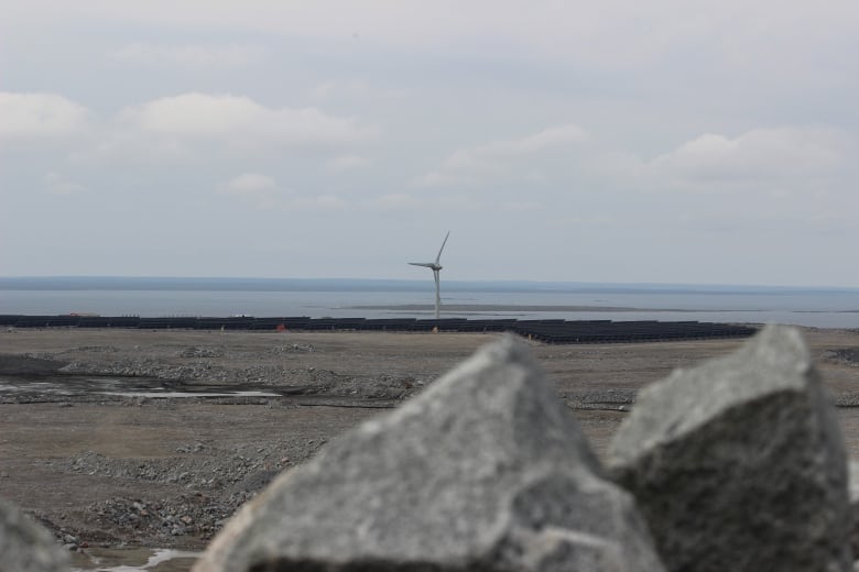 Solar panels and a wind turbine in the background.