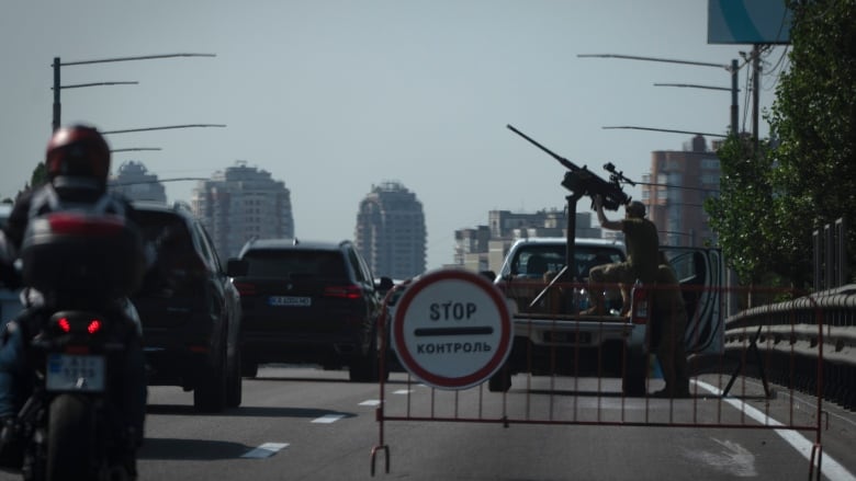 Ukrainian soldiers point a machine-gun toward the sky amid a massive Russian missile-and-drone attack that saw 15 Ukrainian regions affected on Monday.