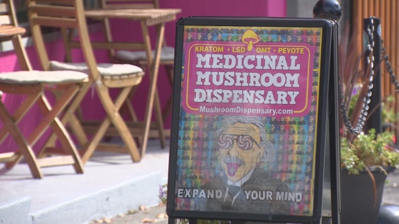 A sidewalk sign outside 651 East Hastings Street in Vancouver advertises a medicinal mushroom dispensary with the words, expand your mind.