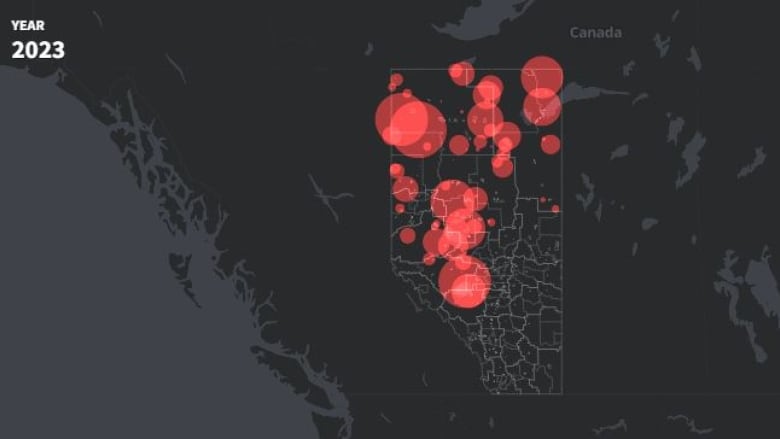 White lines show the boundaries of Alberta communities and counties against a black background. Red circles varying in size, some of which overlap each other, are plotted on the map within Alberta's boundaries.