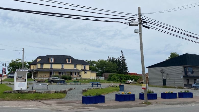 blue flower boxes surround a gravel lot and yellow house