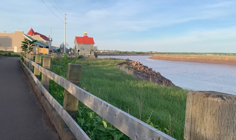 Two-storey, red-roofed building on a riverfront. 